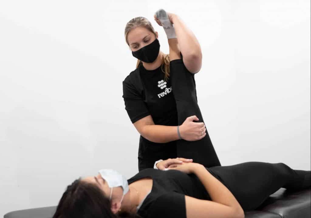 Registered physiotherapist performing stretches on customer.